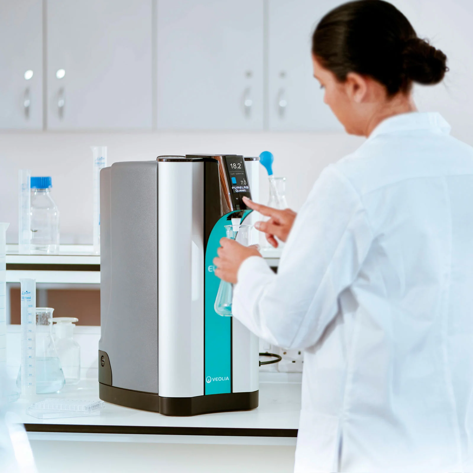 Researcher dispensing ultrapure water from an ELGA PURELAB Quest system.